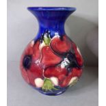 A small Moorcroft Pottery tube-lined bottle vase; of baluster-form and hand-decorated with anemones,