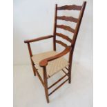 A good and large ladderback open armchair with woven seat and turned legs united by a high turned
