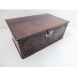 A late 17th century oak box; original strap hinges, incised front with a central stylised tulip