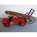 A large custom-built wooden model of a vintage fire engine; extendable ladders and red-painted