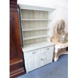 A painted, shabby-chic-style, pine dresser of small proportions; the shelved superstructure above