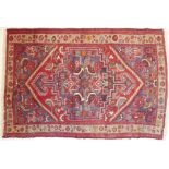 A hand-knotted Hamadan-style red ground rug (145cm x 96cm)