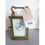 A late 19th / early 20th century brass and glass-sided carriage clock; white-enamel dial with