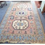 A large hand-knotted 20th century Eastern Turkish rug; central turquoise medallion flanked by two