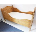 A pine single bedstead with mattress (the headboard 112cm wide)