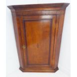 A late 18th century oak and mahogany crossbanded hanging corner cupboard; the panelled door with a