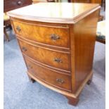 A reproduction figured walnut bow-fronted three-drawer chest raised on bracket feet (56cm wide x