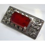 An ornate pierced silver and marcasite brooch of Art Deco inspiration; centrally set with a large