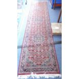 A good hand-knotted red ground Eastern runner (340cm x 80cm)