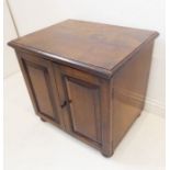 An 18th century-style (later) oak cabinet of small proportions; the moulded top above two fielded