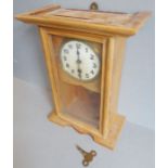 An early 20th century pine-cased mantle clock; cream dial with Arabic numerals behind a single