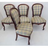 A set of four mid-19th century salon chairs; mahogany and chequer upholstered, balloon backed,