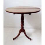 An early 19th century circular mahogany tilt-top occasional table; turned stem and tripod base (some