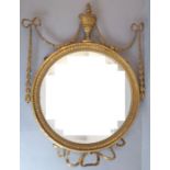 A 19th century circular gilt-framed wall-hanging looking glass in late 18th century style; centred