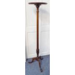 An early 20th century mahogany torchère; the dished top above a tall slender turned stem and on