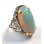 An opal and diamond-set ring, the closed back oval opal cabochon claw-set above an 18-carat white