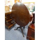 A good 18th century tilt-top circular mahogany occasional table; the one-piece top above a gun-