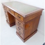 An early 20th century oak pedestal desk; the green tooled inset leather moulded top above an