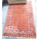 A hand-knotted red ground Pakistan Belouch carpet with gul pattern (295cm x 201cm)