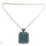 A large and striking silver-mounted pendant set with a natural polished blue/green hardstone;