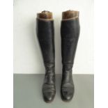 A pair of black-leather riding boots with zip-up backs and wooden riding-boot trees, each with