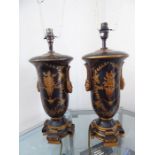A very decorative pair of black ground with gilt highlight table lamps; decorated with wreaths and