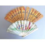 An early 20th century pierced wooden fan decorated with various Swiss costume, together with a