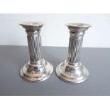 A pair of hallmarked silver (filled) dwarf table candlesticks with reeded columns, assayed London