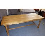 A large and heavy light oak refectory table in excellent condition, the cleated planked top above