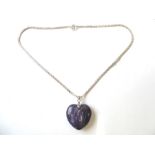 A heart-shaped polished purple hardstone and silver mounted pendant upon a silver chain (boxed)