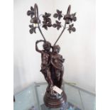 A bronze-style figural lamp modelled as a young couple upon rockwork and with branches and leaves