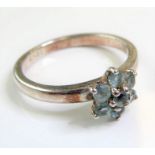 A lady's silver dress ring set with hand-cut light blue stones in a flowerhead cluster design (