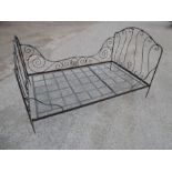 A folding wrought-iron garden bedstead; black-painted and in the French style (74" x 48" and 43"
