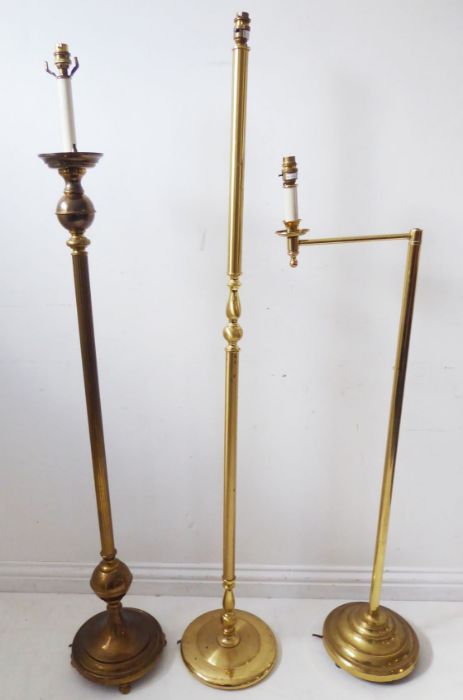 Three brass lamp standards on circular bases (the tallest 150cm high)