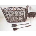 A wrought-iron and wire-mesh folding fire screen together with an ornately pierced iron trivet and