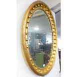A good oval gilt-framed wall-hanging looking glass; the frame with reeded outer border and inner