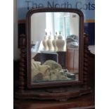 A large 19th century oak swing-mirror; lidded compartment and the mirror plate flanked by barley-