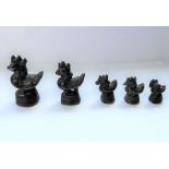 A set of five concentric patinated bronze Burmese opium weights modelled as cockerels on stands (the