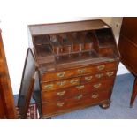 An early 18th century oak writing bureau of small proportions; the cleated angular fall with moulded