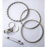 Six items of silver jewellery by Georg Jensen; a plain bangle numbered '51A'; a rope finish and