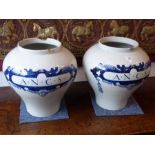 A pair of early style (early 20th century) large Dutch Delft baluster-shaped cannisters (possibly