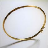 A 9-carat yellow-gold bangle with safety clip, internal diameter approx. 5.5cm, weight 3.1g