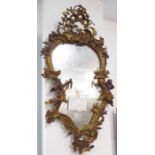 A 19th century gilt-framed wall-hanging looking glass in high mid 18th century Rococo-style; pierced