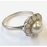 A pearl and diamond-set cluster ring, the 7mm central pearl (untested) to the cushion-shaped old-cut