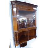 A late 19th / early 20th century mahogany hanging corner cupboard by Liberty & Co. (London); the