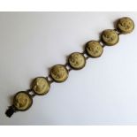 A 19th century bracelet formed as seven oval carved cameos in relief from lava (17.5cm)