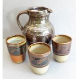 Modern Winchcombe Pottery - a  jug (20cm high) and three beakers; each decorated with a wavy-style