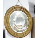 A 19th century circular gilt-framed wall-hanging looking glass having intaglio border surrounding an