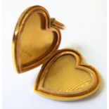 An Edwardian 15-carat yellow gold, heart-shaped locket; plain polished exterior and suspensory loop,