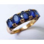 An oval sapphire five stone ring to the shank engraved '18K', size P (3.4g) Condition Report: Stones